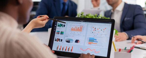 Équipe multiethnique analysant des données sur Power BI lors d'une réunion de projet dans un bureau moderne