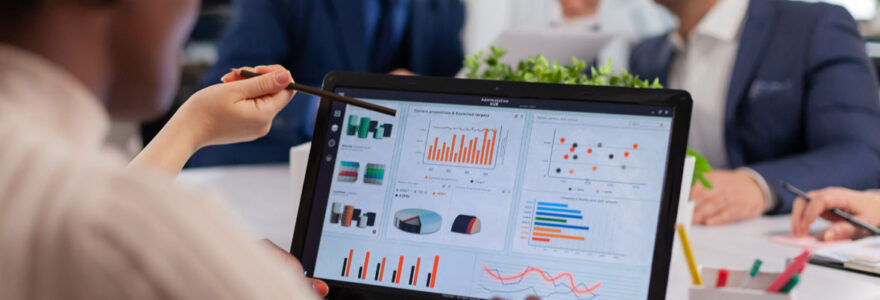 Équipe multiethnique analysant des données sur Power BI lors d'une réunion de projet dans un bureau moderne