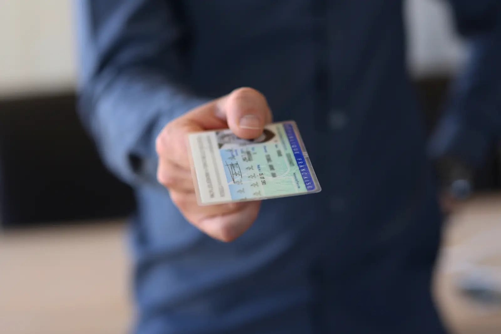 Une personne photographie sa pièce d'identité avec son smartphone dans le cadre de la procédure de vérification d'identité à distance